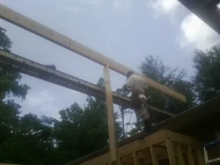 Carpenter setting a ridge beam over a new addition frame — Ice Dam Removal by Roofing Brothers in Glen Mills