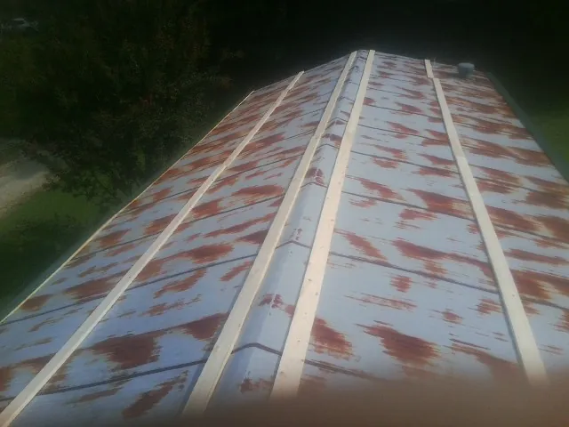 Rusted metal roof panels with new wood purlins before replacement — Storm Damage Roof Repair in Glen Mills by Roofing Brothers