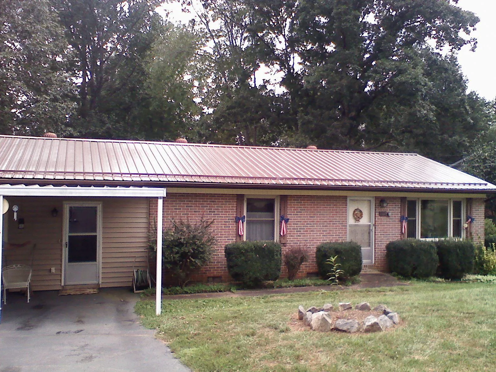 Bronze metal roof and carport on a brick ranch home — Roof Repair work by our crew in Glen Mills